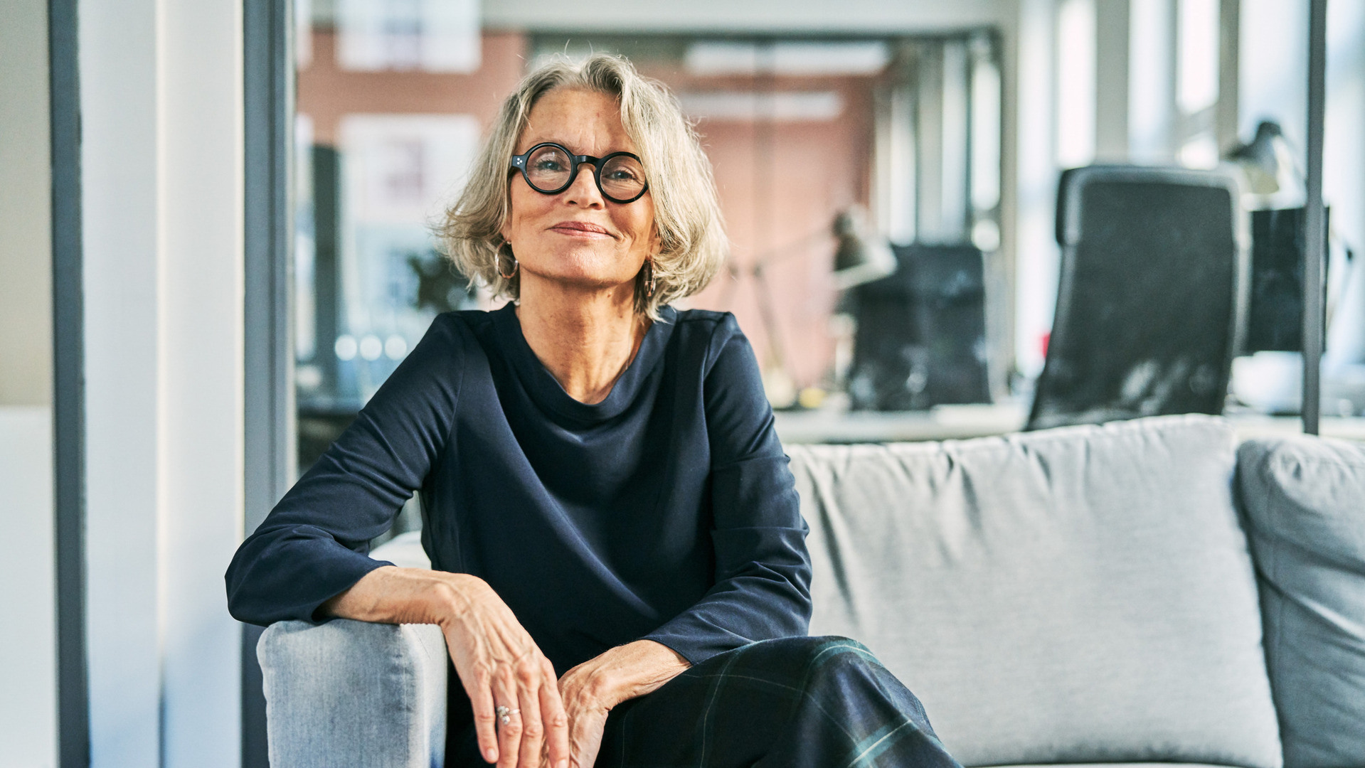 Eldre dame som sitter i en sofa